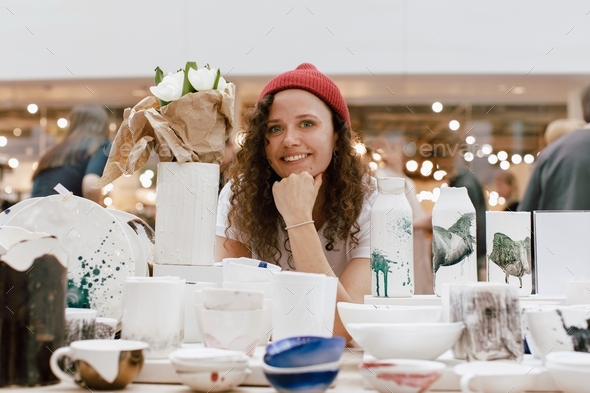 Girl selling handmade ceramics market counter