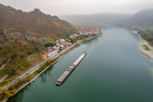A Barge Transporting Cargo and Freight Along the River Danube on a Foggy Morning