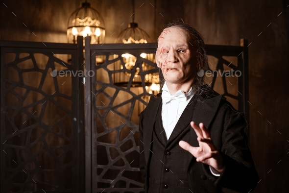 an ugly man in a tailcoat holds out his hand - cosplay for the musical \