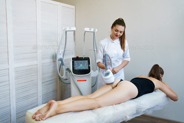Woman receiving treatment for cellulite. Slimming vacuum massage machine.