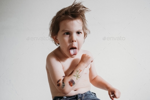 Toddler boy with temporary tattoos on hand