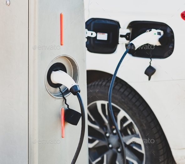 The electric car charger plugged in to the socket.The modern electric car charging the battery.