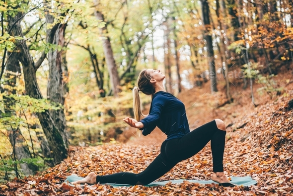 Woman doing yoga at the autumn forest. - Stock Photo - Images
