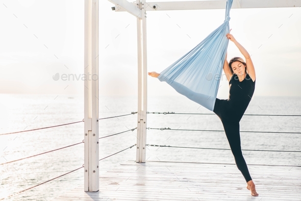 Woman doing yoga in a hammock. - Stock Photo - Images