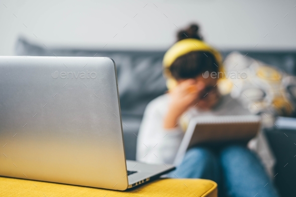 Bored woman sitting near laptop. Concept of quarantine for coronavirus working from home. - Stock Photo - Images