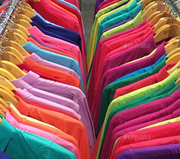 Two rows of colourful clothes hanging in a shop - Stock Photo - Images