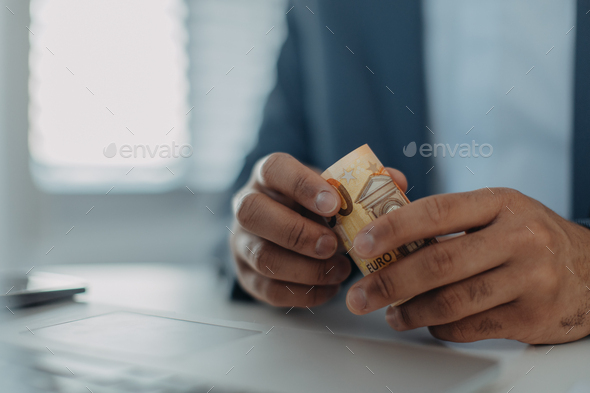 Close-up of businessman man holding euro money, inflation concept.