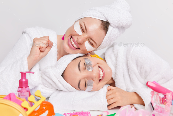 Positive women make beauty treatments after shower apply pads under eyes to reduce dark circles tilt