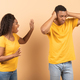 Misunderstanding in couple, marriage, family. Furious black lady shouting at her annoyed man, peach - PhotoDune Item for Sale