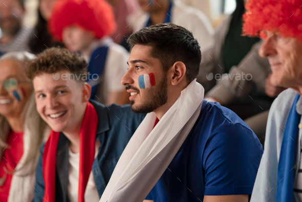 French football fans celebrating their team\'s victory at stadium.