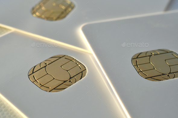 Close up of gold chips microchips embedded on blank white credit cards