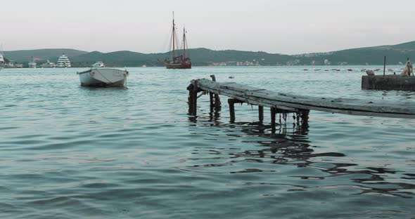 A Boat Tied To a Wooden Pier in the Sea in the Evening