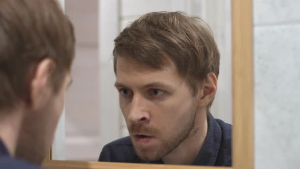 Excited determined man looking at his reflection. Endurance, motivated and power concept. alt