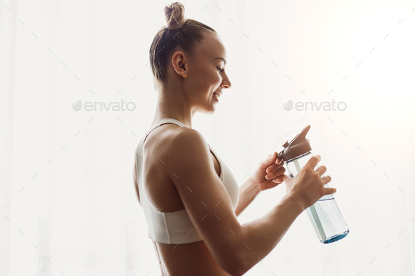 Happy slim woman with bottle of water