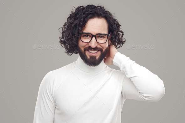 Smiling bearded man with curly hair in eyeglasses
