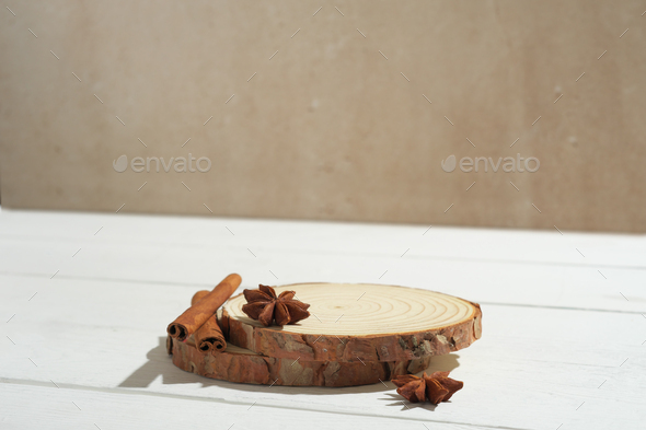 natural round wooden podium for product placement, cinnamon sticks and anise stars  - Stock Photo - Images
