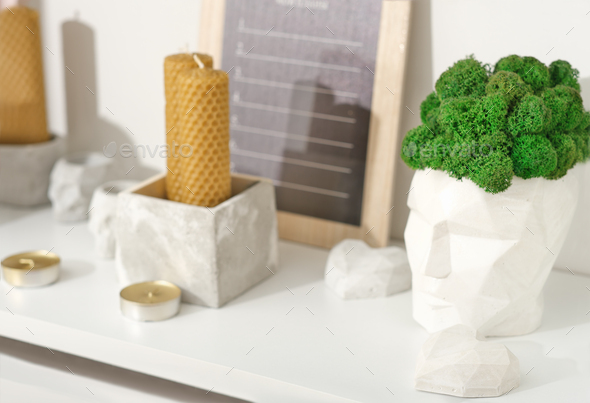 modern trendy loft house decor, beeswax candles, concrete boxes and vases with natural green moss. - Stock Photo - Images