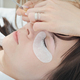 close up of caucasian woman client lying with eye closed during lash extension procedure.  - PhotoDune Item for Sale