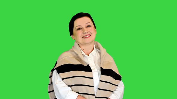 Mature Woman Standing and Smiling To Camera on a Green Screen Chroma Key alt
