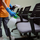 Cleaner in rubber gloves using spray-disinfectant on chairs - PhotoDune Item for Sale