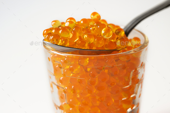 Red Caviar in the Silver Spoon over little individual Caviar jar - Stock Photo - Images
