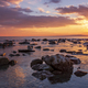 sunset over the sea with a rocky beach. - PhotoDune Item for Sale