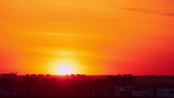 Morning sky at dawn with a large sun rising over the city, sunrise timelapse
