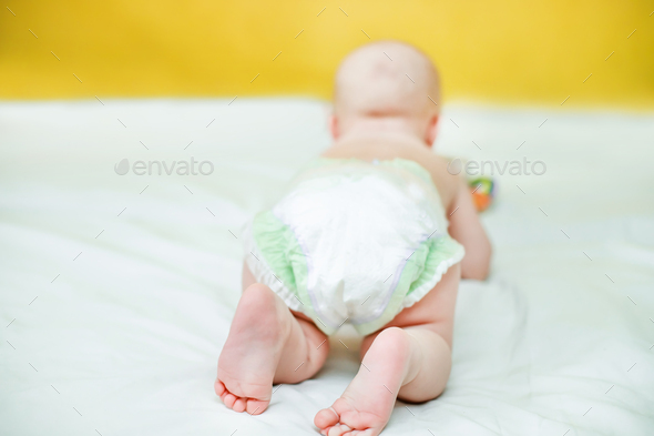 Rear view of a child crawling in a pump. Infant hygiene. Protection against the flow of urine for