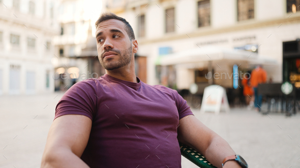 Attractive man looking around waiting girlfriend while sitting in the cafe outdoors - Stock Photo - Images