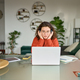 Young woman in headphones using laptop watching online webinar learning at home. - PhotoDune Item for Sale