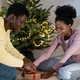 Happy african couple prepare for New year at home, black man and woman wrapping Christmas gifrs - PhotoDune Item for Sale