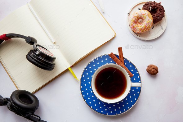 Mock up notepad with headphones, coffee cup with doughnuts. Online work, freelance, taking webinar