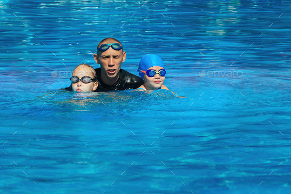 individual active lessons of the coach with children in swimming in the outdoor pool