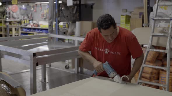 Worker cuts board for project alt