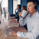 Focused asian businessman drinking coffee while working on computer in modern office - PhotoDune Item for Sale