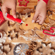 Unrecognizable person decorates gingerbread cookies prepares traditional food messy table with items - PhotoDune Item for Sale