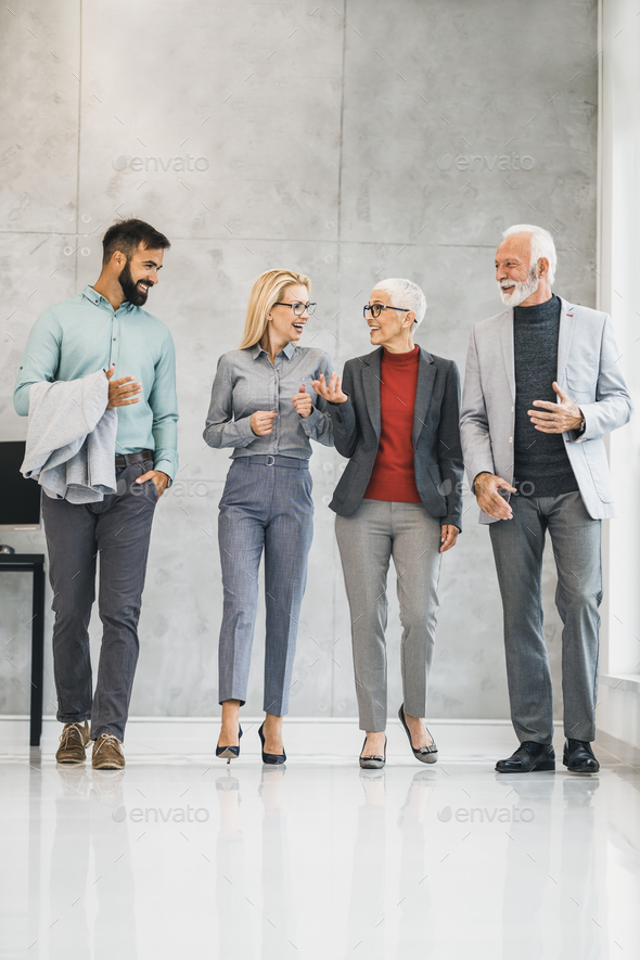 A Group Of A Business People Walking Along The Office Hallway And Having A Discussion - Stock Photo - Images