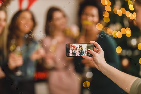 Multiracial Group Of Friends Making Memories Photos With Smartphone During Celebrating Christmas - Stock Photo - Images