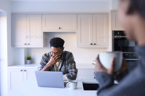 Couple At Home Working On Laptop On Counter In Kitchen - Stock Photo - Images
