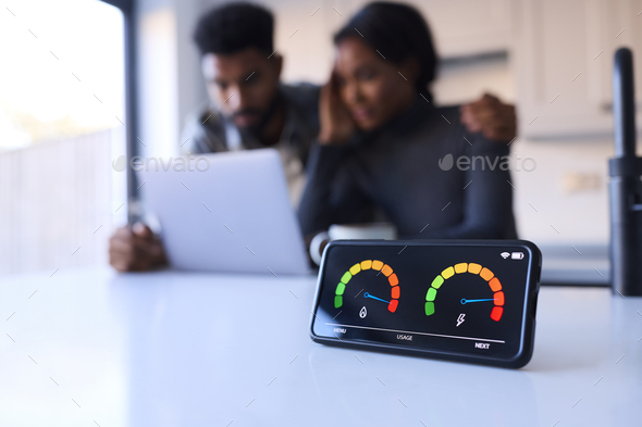 Worried Couple At Home Looking At Laptop With Smart Energy Meter In Foreground - Stock Photo - Images
