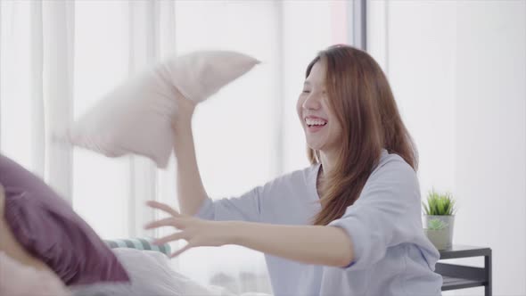 young lesbian couple playing to each other with love moment on the sofa in bedroom surrounded