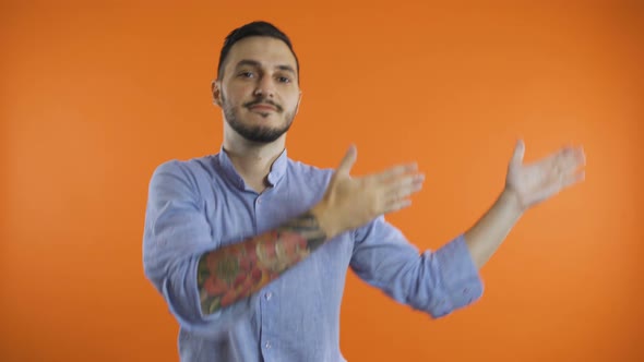 Young Smiling Man in Shirt Doing Winner Happy Dance, Presenting To Side with Both Arms alt