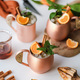 Alcohol cocktail drinks with tangerine and cinnamon in copper mugs - PhotoDune Item for Sale