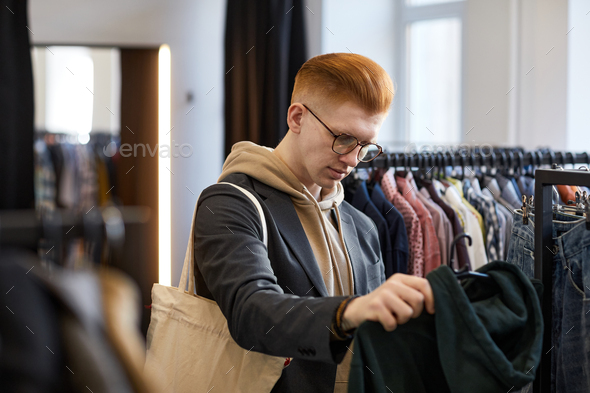 Young red haired man in thrift shop