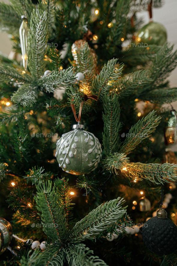 Christmas tree with vintage baubles and golden lights close up in