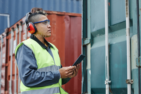 Female worker wearing ear protection at shipping docks