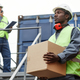 African American worker carrying boxes at shipping docks - PhotoDune Item for Sale