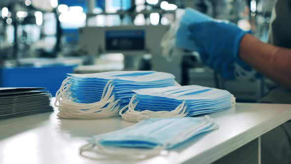 Face Masks Being Stacked on a Table. Coronavirus Protection Mask Production Line. alt