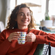 Young happy pretty woman drinking tea or coffee relaxing smiling at home. - PhotoDune Item for Sale