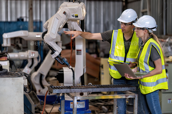 In robotic training instructor teach girl engineer to program robot arm ...
